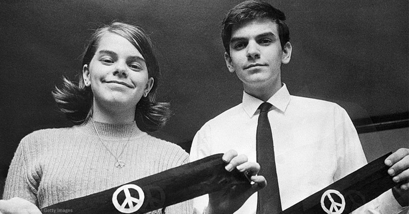 photo of mary beth + john tinker holding black armbands with peace signs